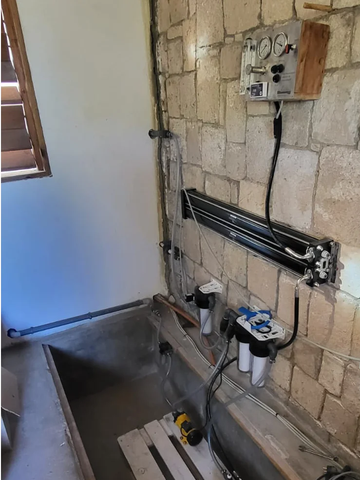 A modular watermaker installer on the wall of a beach house in Madagascar